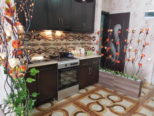 a kitchen with black cabinets and a stove top oven at Subtropic City in Batumi