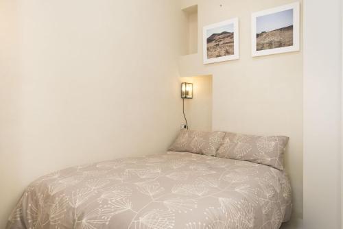 um quarto com uma cama num quarto branco em Iolanda Apartment 30m from Seaside em Alghero