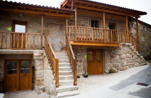 une maison en pierre avec un escalier et deux portes dans l'établissement Albergue do Xurés, à Maus de Salas
