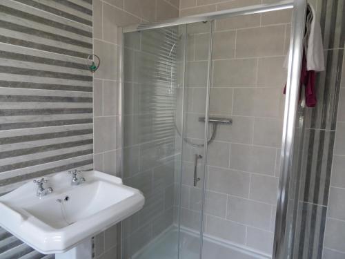 a bathroom with a sink and a shower at Leam Cottage in Belmullet