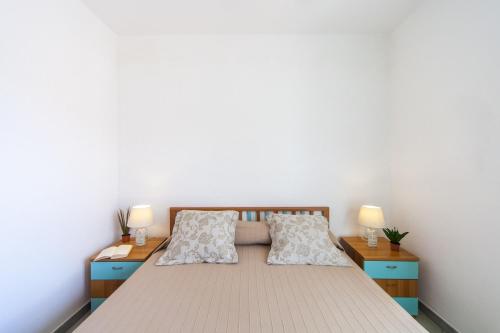 a bedroom with a bed with two night stands and two lamps at Villa Victory in Specchiolla 