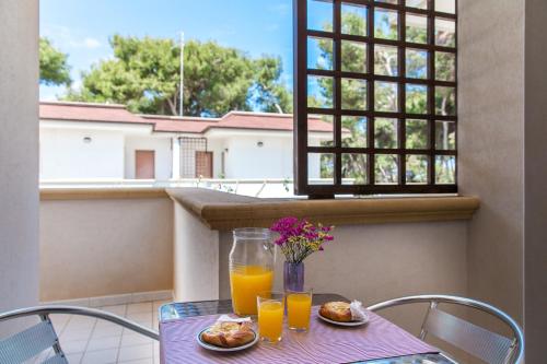 a table with two plates of food and orange juice at Villa Victory in Specchiolla 