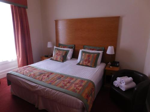 a hotel room with a bed and a chair at Horizon Hotel in Ayr