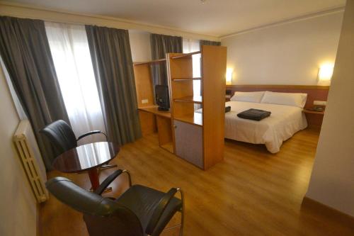 een hotelkamer met een bed en een stoel bij Hotel Brujas De Irues in Tarazona de Aragón