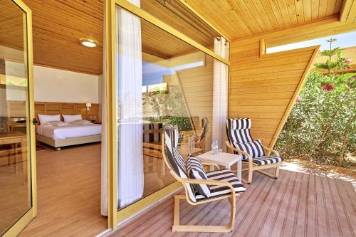 a porch with two chairs and a table and a bed at Hotel Dakhla Club in Dakhla