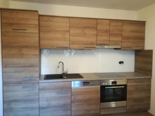 a kitchen with wooden cabinets and a sink and a stove at Häus`l am Ruan in Berwang