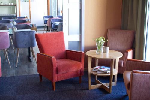 a waiting room with chairs and a table and a table sidx sidx at Hotel Marena in Andenes