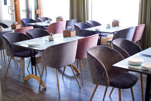 a row of tables and chairs in a restaurant at Hotel Marena in Andenes