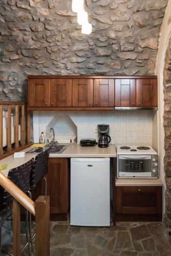 a kitchen with a stove and a white refrigerator at Avgonima All Seasons Hotel in Avgonyma