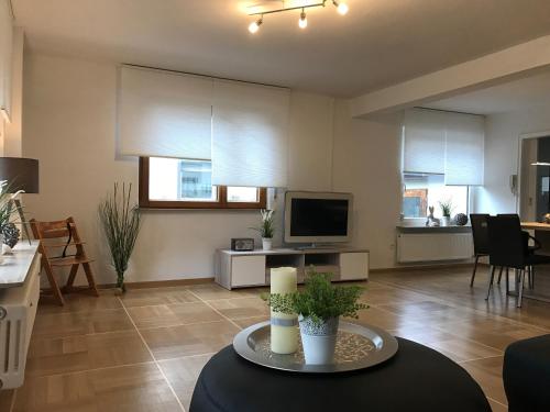 a living room with a table and a tv at Ferienhaus Vier Jahreszeiten in Bad Urach