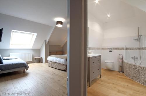 une chambre avec un lit et une salle de bain avec baignoire dans l'établissement La Corbonniere, à Geneslay