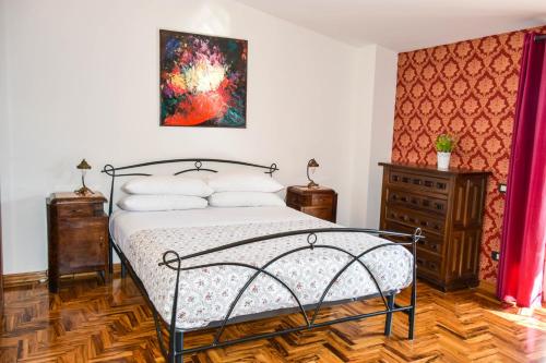 a bedroom with a bed and a painting on the wall at La Quiete in Anagni