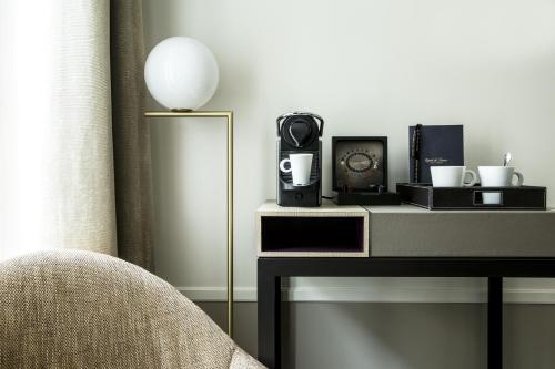 a living room with a table with a speaker on it at Hôtel La Tamise - Esprit de France in Paris