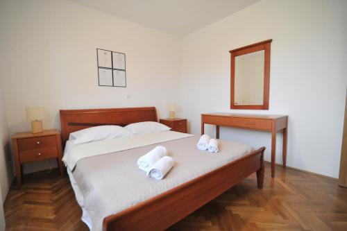 a bedroom with a bed with two towels on it at Villa Luna with Seaview in Petrcane