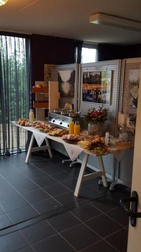 een keuken met twee tafels met eten erop bij B&B Bovenweg in Rhenen