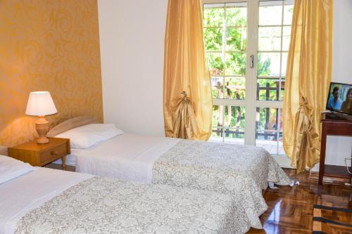 two beds in a hotel room with a window at La Quiete in Anagni