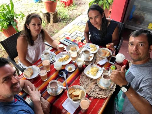 a group of people sitting around a table eating food at Hostal Tongo Reef in Puerto Baquerizo Moreno