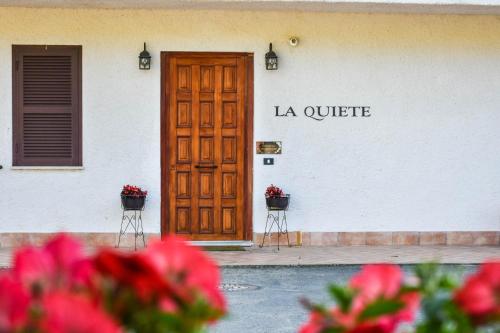 a building with a wooden door and two baskets of flowers at La Quiete in Anagni