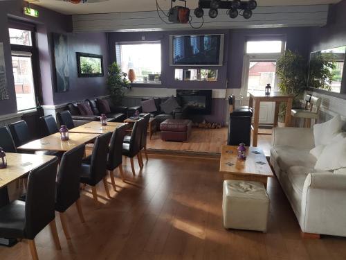 a living room with tables and chairs and a couch at Sutherlands Hotel in Gateshead