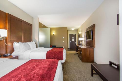 a hotel room with two beds and a television at Comfort Suites Regina in Regina