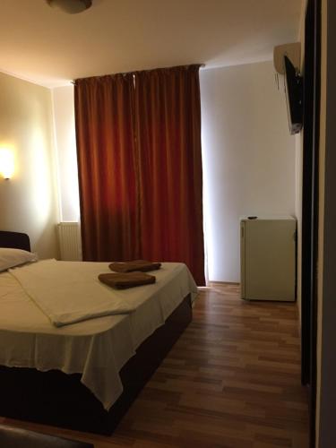 a bedroom with a bed and a red curtain at Vila DG in Mamaia Nord
