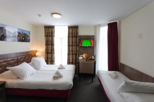 ein Hotelzimmer mit 2 Betten und einem Sofa in der Unterkunft Hotel Park Plantage in Amsterdam