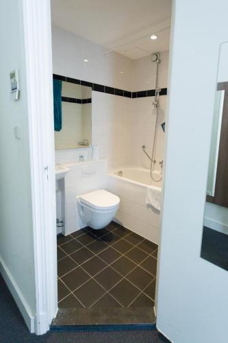 a bathroom with a toilet and a tub and a sink at Hotel Park Plantage in Amsterdam