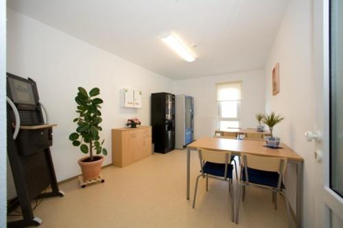 a room with a table and a kitchen with a dining room at Nibelungenmotel Pöchlarn in Pöchlarn