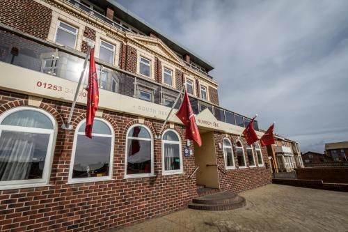 a brick building with red flags in front of it at Number One South Beach in Blackpool