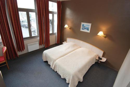 サントメールにあるHôtel Les Franginsの窓付きの部屋にベッド付きのベッドルーム1室があります。