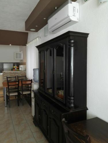 a kitchen with a black cabinet and a dining room at Sobe BCRNJAC in Međugorje