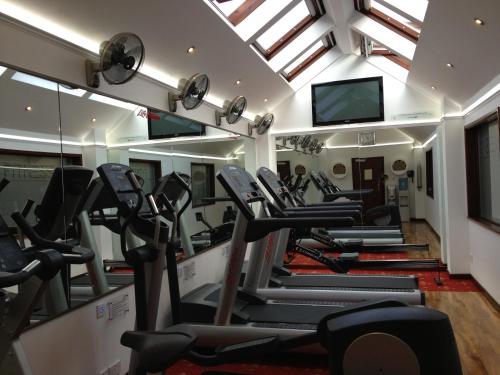 a gym with treadmills and a row of ellipticals at Hollies Hotel in Martock
