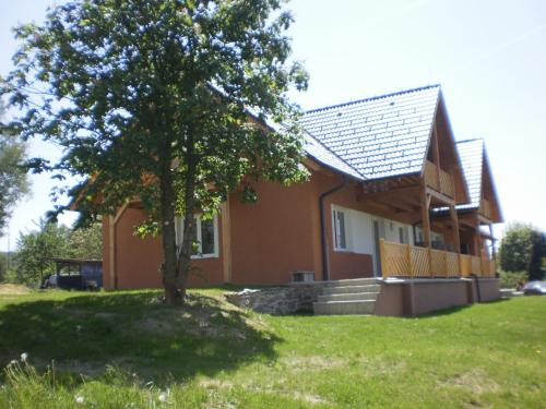a house with a tree in front of it at Apartmány Eva Frymburk in Frymburk