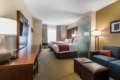 a hotel room with a bed and a couch at Comfort Suites Regina in Regina