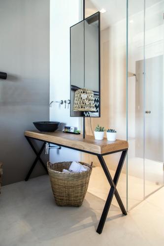 a bathroom with a table with a mirror and a basket at My Mykonos Hotel in Mýkonos City