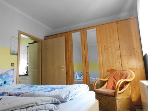 ein Schlafzimmer mit einem Bett und einem Stuhl darin in der Unterkunft Bungalow Idylle Am See in Neuruppin