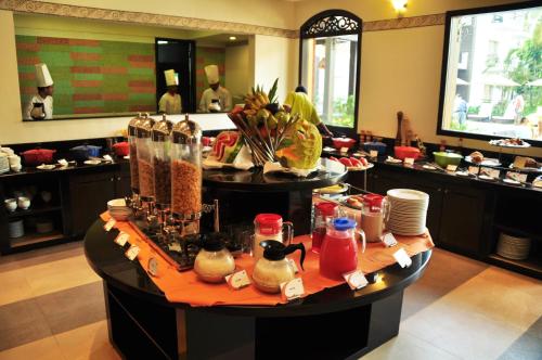 a restaurant with a table with food on it at Kyriad Prestige Calangute Goa by OTHPL in Calangute