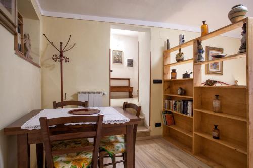 een eetkamer met een tafel en een boekenplank bij Il Nido Di Asia in Cortona