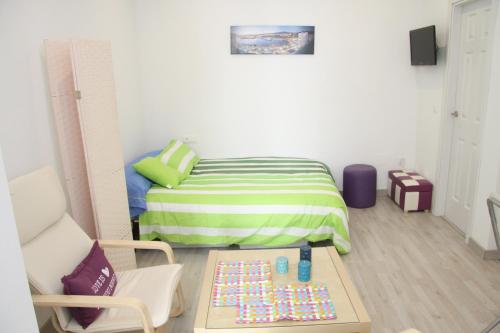 マラガにあるTG FreshApartments by Bossh! Apartmentsのベッドとテーブル付きの小さな部屋