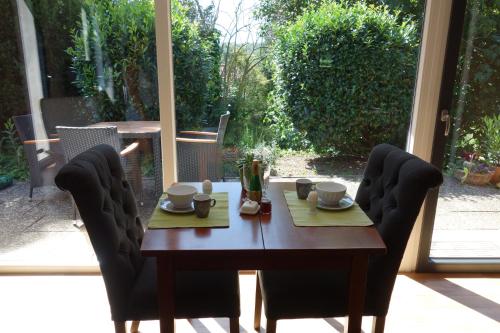 ブラウンフェルスにあるFerienhaus Braunfelsの木製テーブル(椅子2脚付)、テーブル(カップ、皿付)