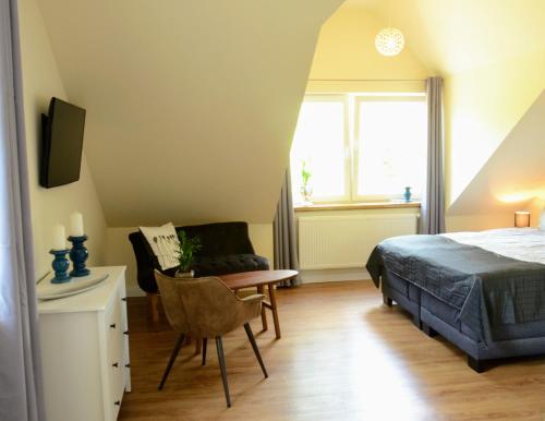Schlafzimmer mit einem Bett, einem Schreibtisch und einem Stuhl in der Unterkunft Pension am Birkensee in Detern