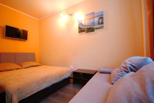 オリギンカにあるStudio on Zvezdnayaのベッド2台とソファが備わるホテルルームです。