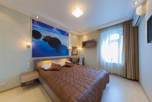 شقة بريستيج هول في كييف: غرفة نوم مع سرير مع لوحة كبيرة على الحائط