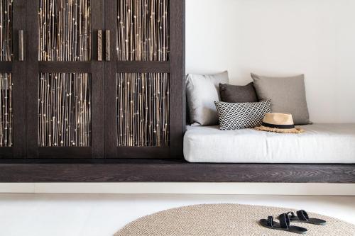a living room with a couch with a hat and shoes at My Mykonos Hotel in Mýkonos City