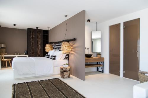 a bedroom with a white bed and a table at My Mykonos Hotel in Mýkonos City