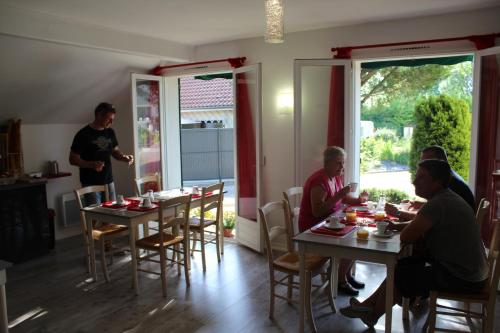 a group of people sitting at tables in a restaurant at Villa Hotel in Troyes