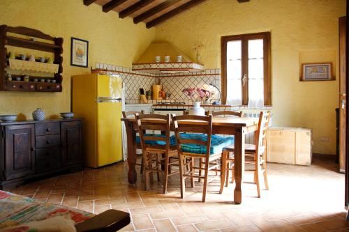 a kitchen with a table and chairs and a yellow refrigerator at Casale Vigna Carbona in Gavorrano