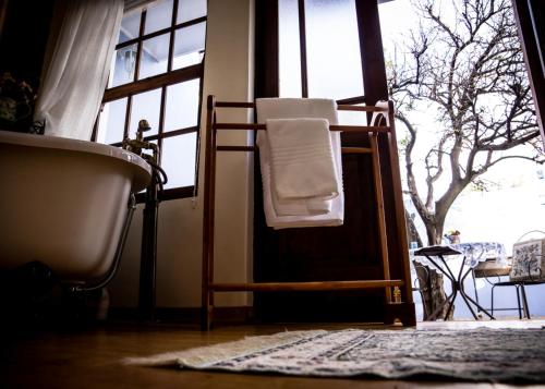 a bathroom with a bath tub and a towel on a chair at Mon-Ae Guesthouse in Klerksdorp