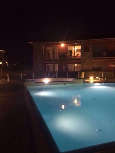 a swimming pool at night in front of a house at Residence Villa Paradiso in Gravedona