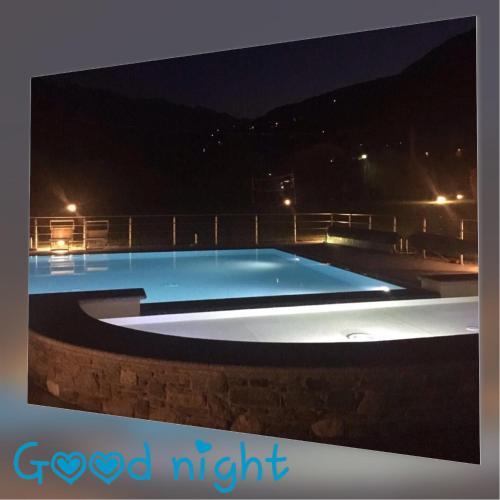 a swimming pool lit up at night at Residence Villa Paradiso in Gravedona